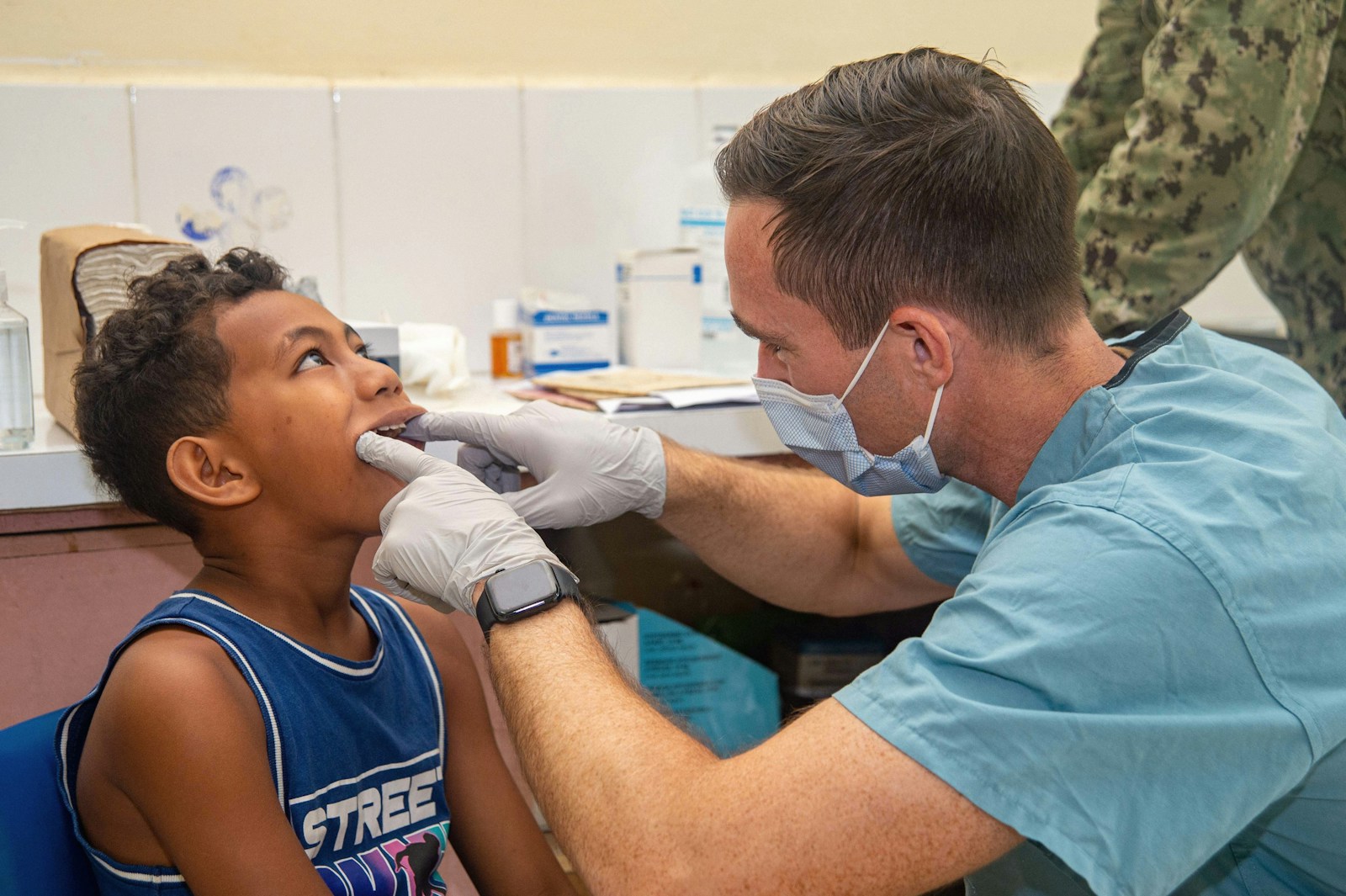 A clinician examining a young patient's teeth
